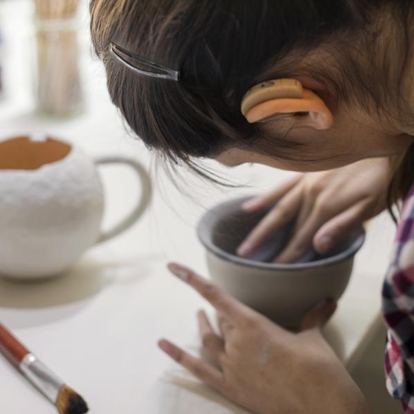 Une femme malentendante fait de la poterie artisanale dans un atelier