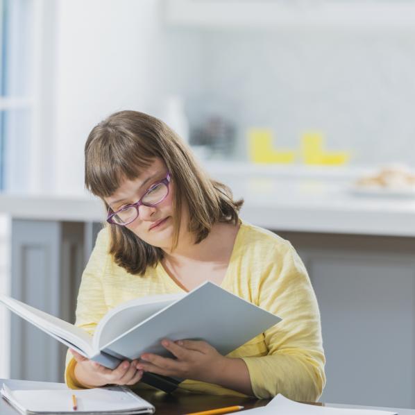 Une jeune femme lit un livre qu'elle a emprunté à une bibliothèque adaptée