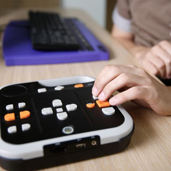 Personne aveugle utilisant un lecteur de livre audio pour malvoyants