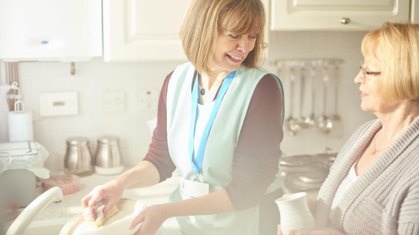 femme aidant un senior à faire la vaisselle. Aide ménagère.