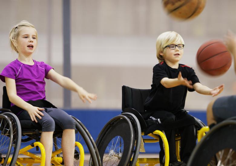 Deux enfants pratiquent du handisport dans un gymnase