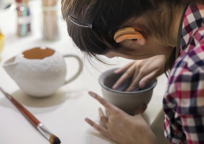Une femme malentendante fait de la poterie artisanale dans un atelier